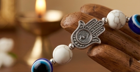 Collage of a bracelet with decorative elements on a wooden surface, featuring the brand 'Svasti'.