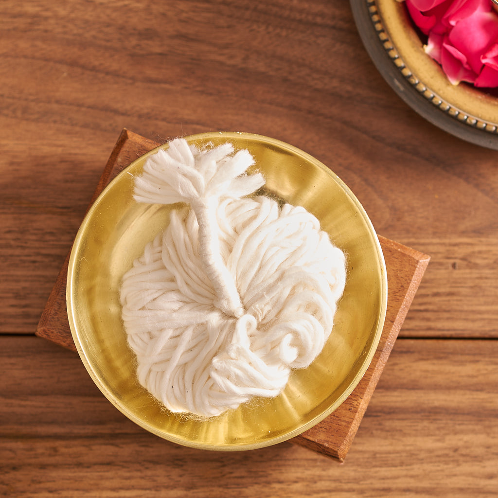 Decorative white flower on a gold plate with a wooden base on a wooden surface