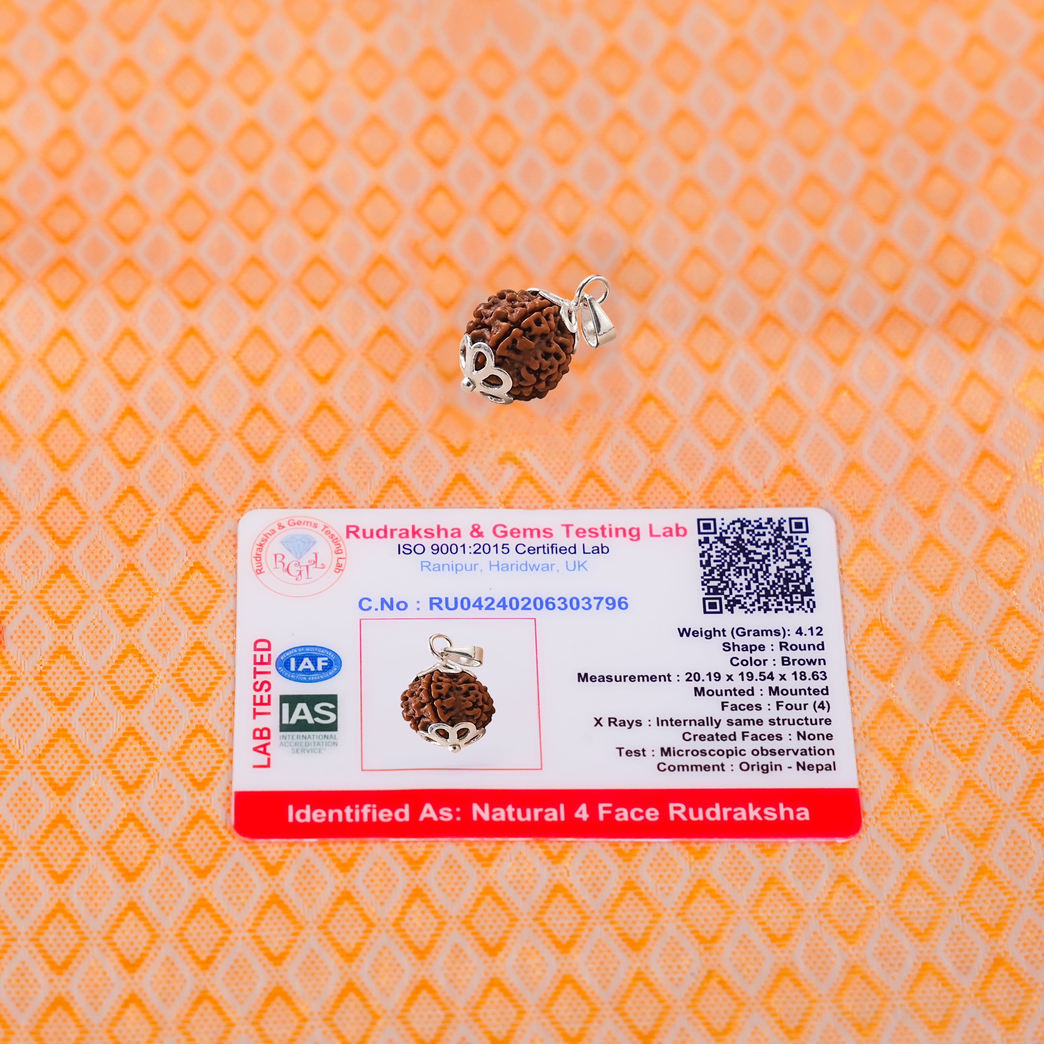Rudraksha bead with a testing label on an orange patterned background