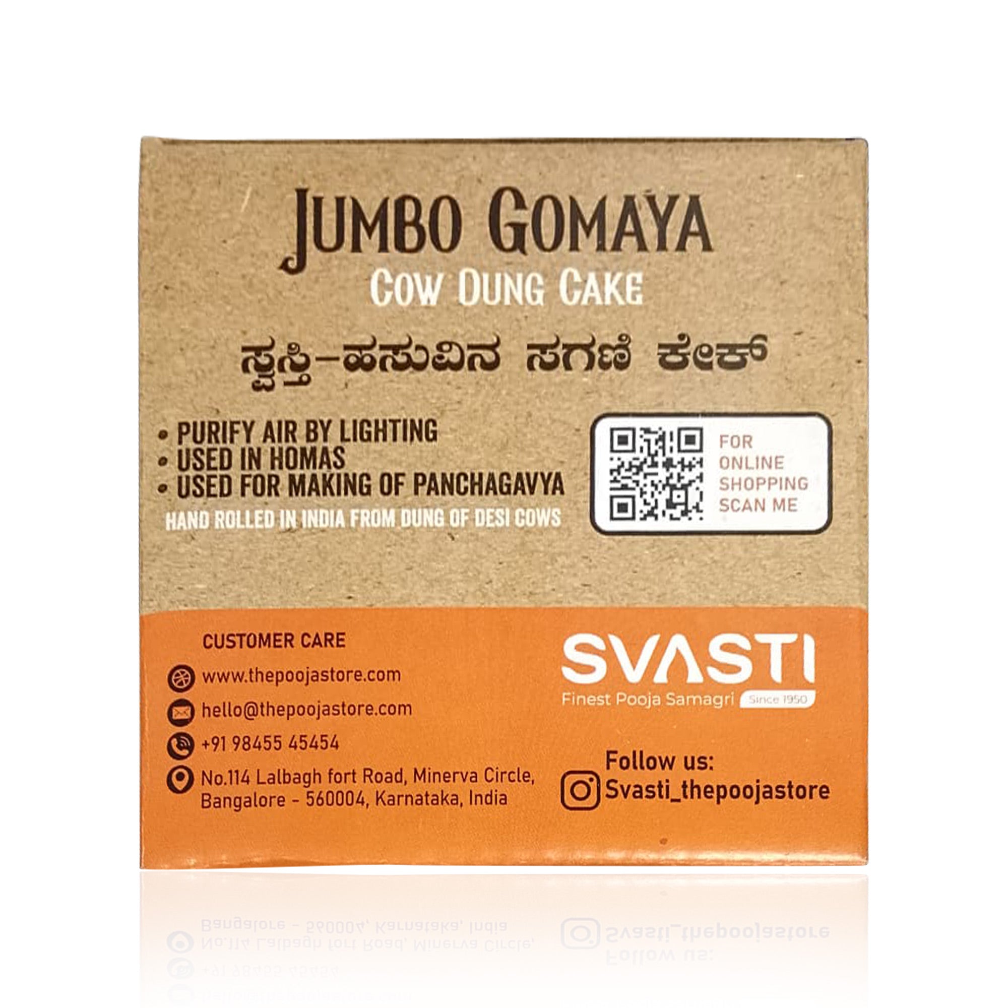 A square kraft paper box for 'Jumbo Gomaya Cow Dung Cake' by the brand SVASTI, featuring black text, a QR code, and contact details on an orange band at the bottom, set against a white background with a soft reflection.