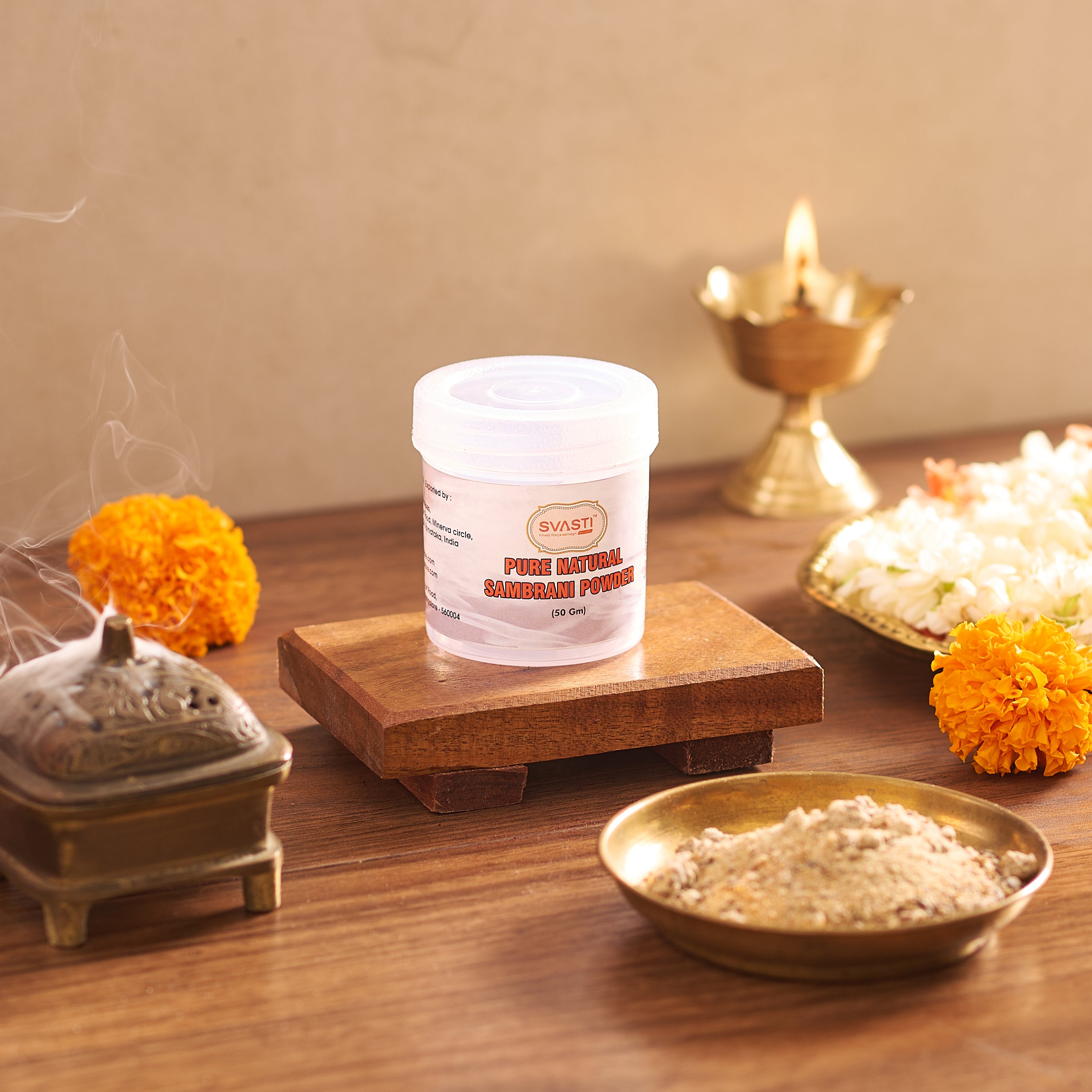 Container of Swasti brand powder on a wooden platform with decorative elements in the background