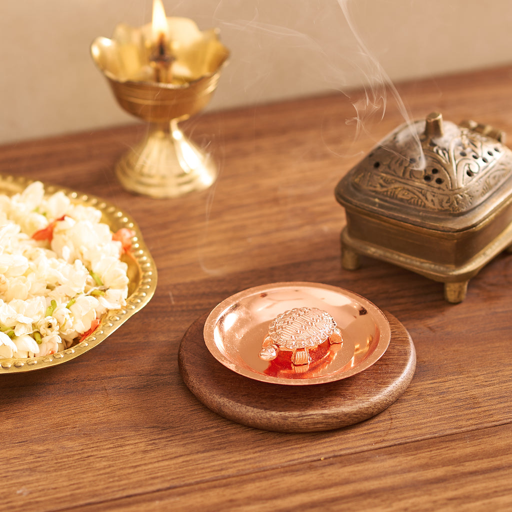 Candle, incense burner, and dish of popcorn on a wooden surface