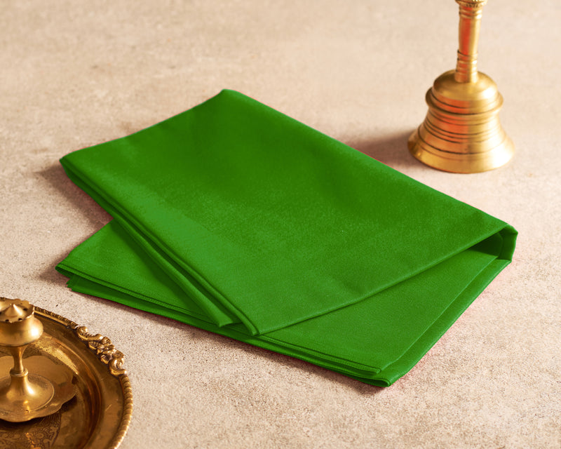 Green fabric on a beige surface with gold decorative items