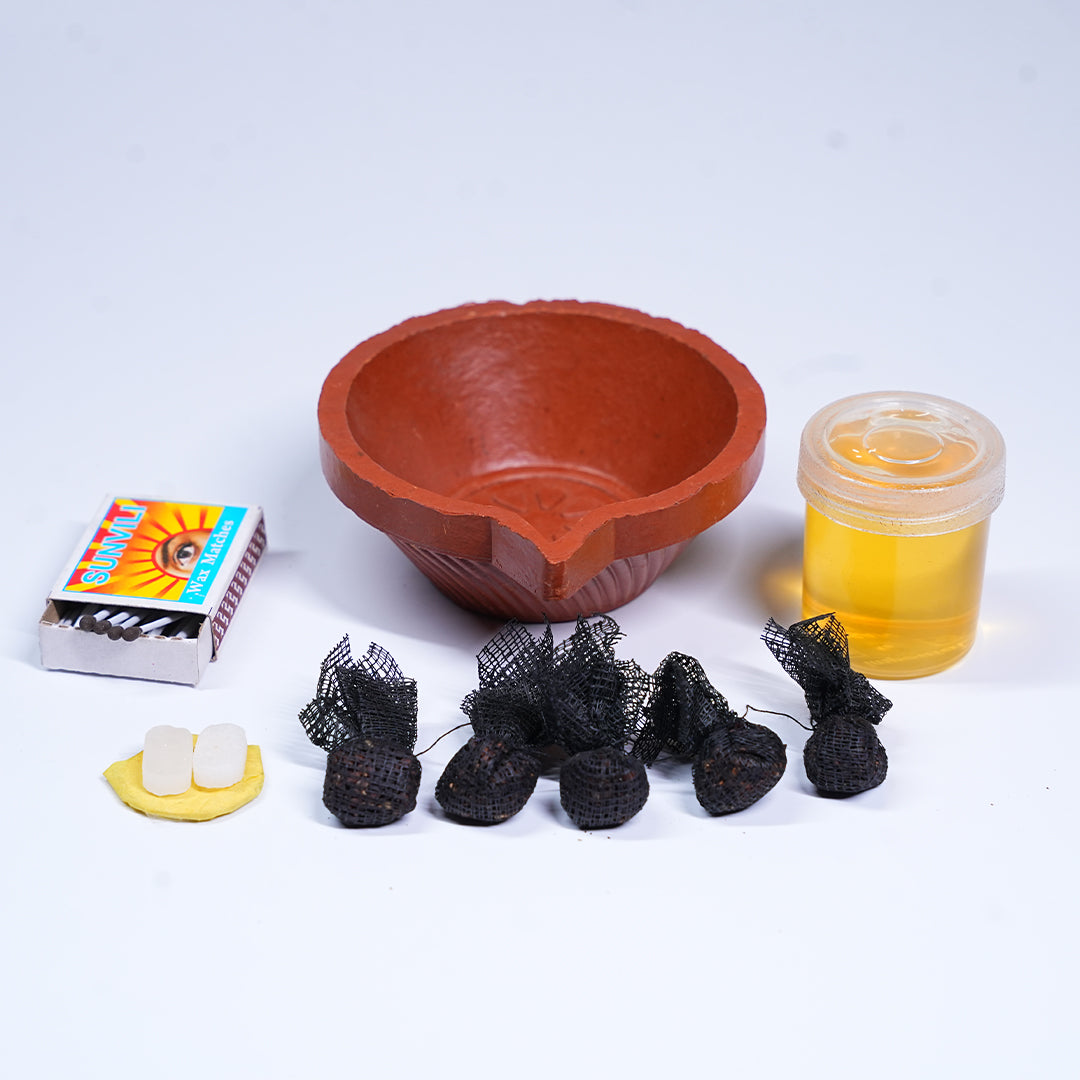 Terracotta oil lamp with matches, cotton wool, and oil on a white background