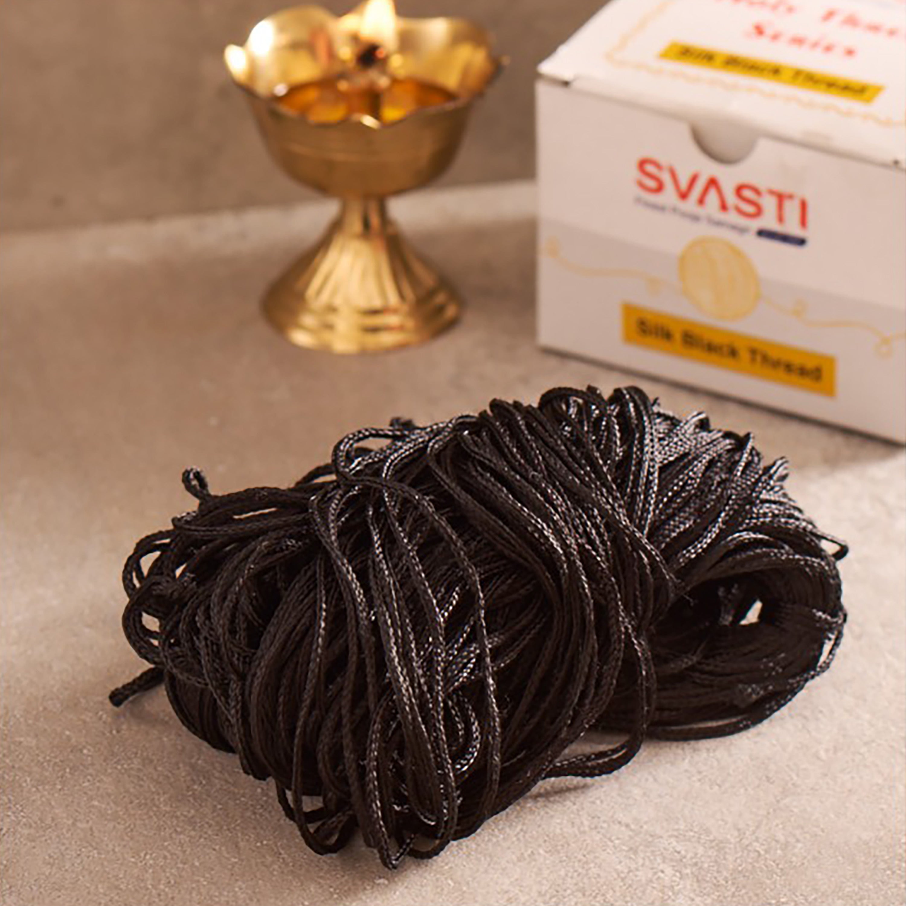 Ball of black thread with SVASTI packaging in the background