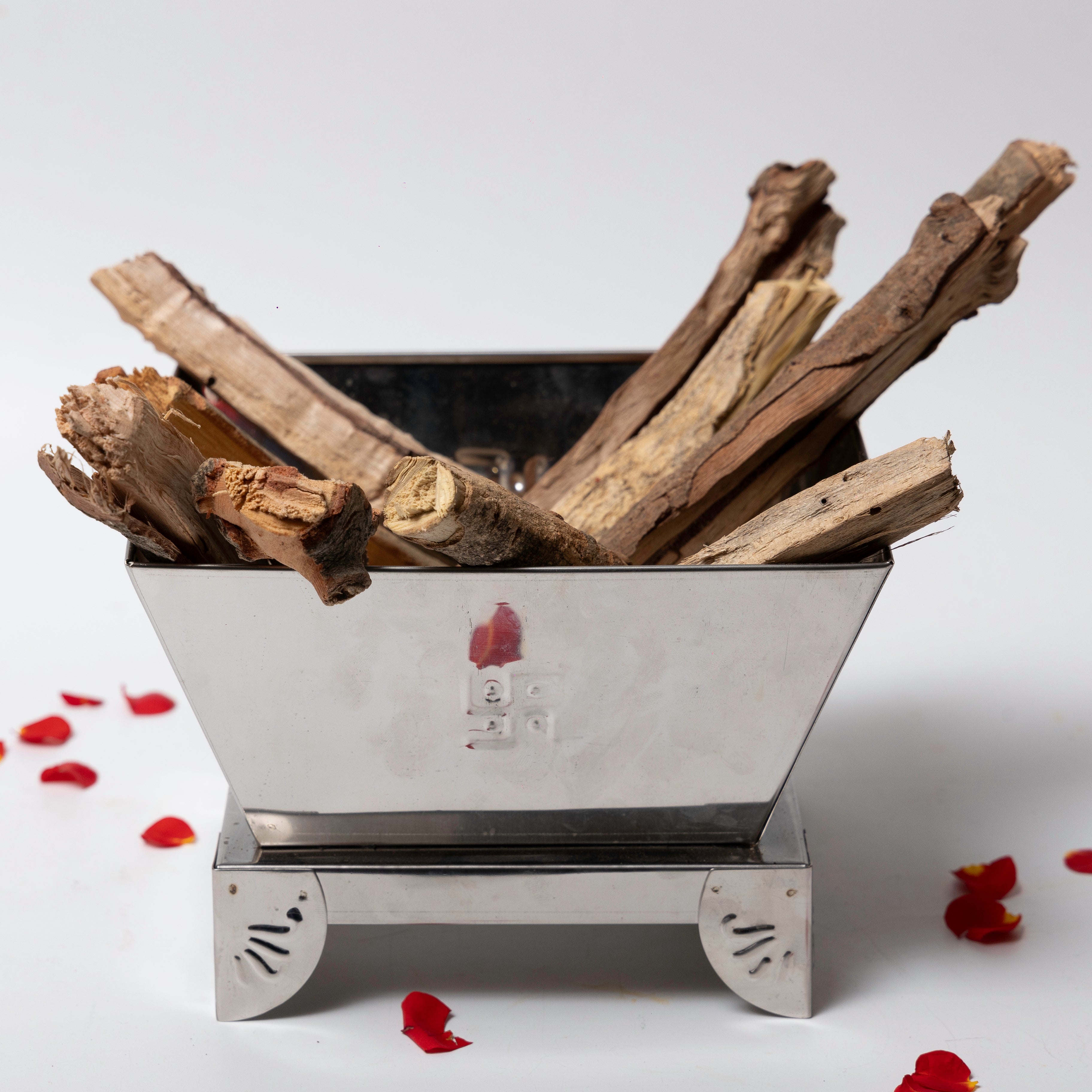 Metal fire pit with wooden logs on a white background