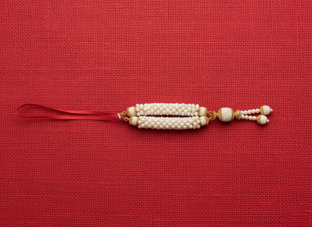 Decorative string with pearls and gold accents on a red background