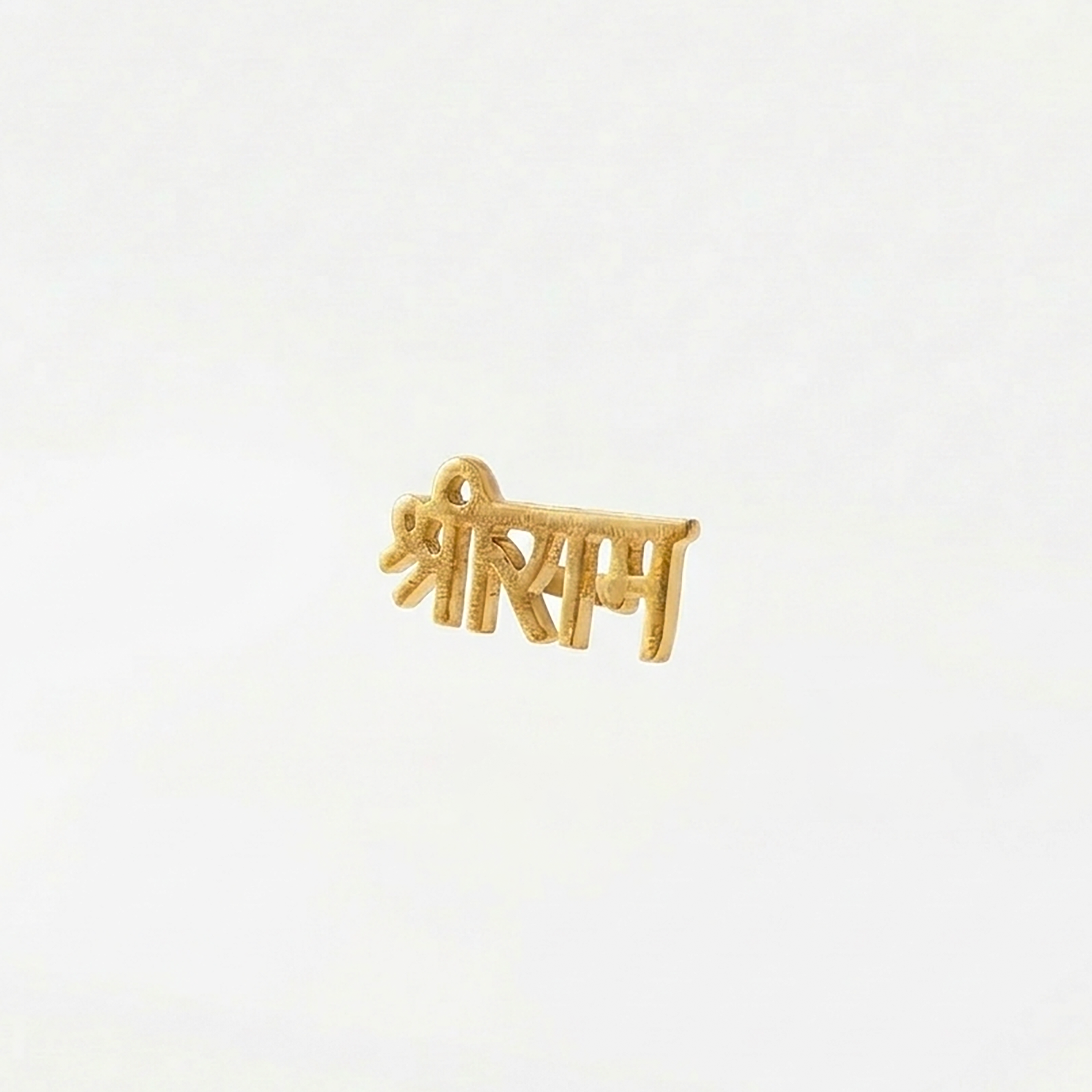 Gold pendant with engraved text on a white background
