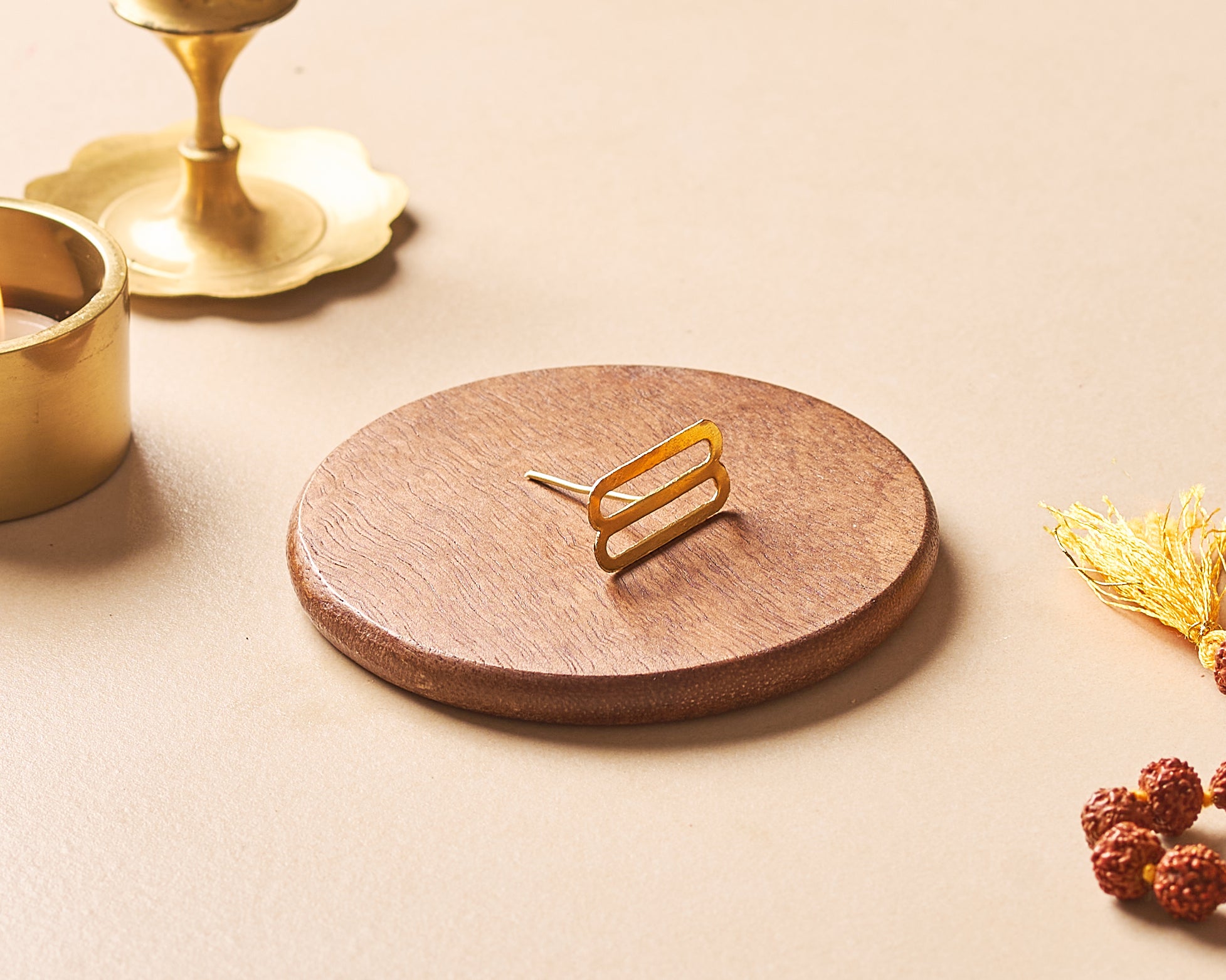 Wooden coaster with gold coaster holder on a beige surface