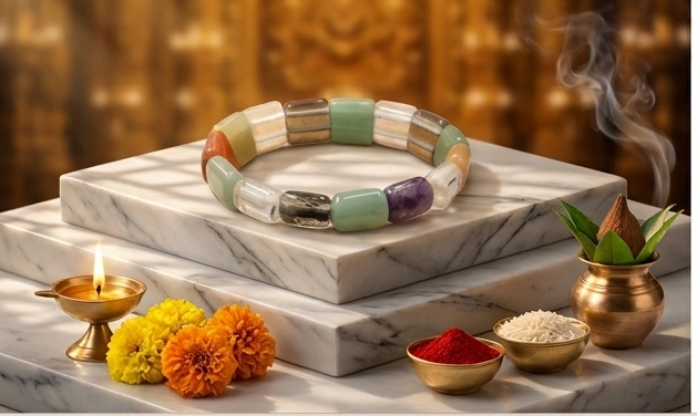 Collage of a colorful bracelet on a marble surface with decorative elements and candles.