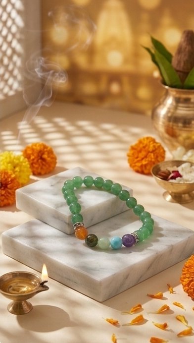 Collage of Svaasti Pooja Items including a bracelet and other decorative items on a marble surface with candles and marigold flowers.