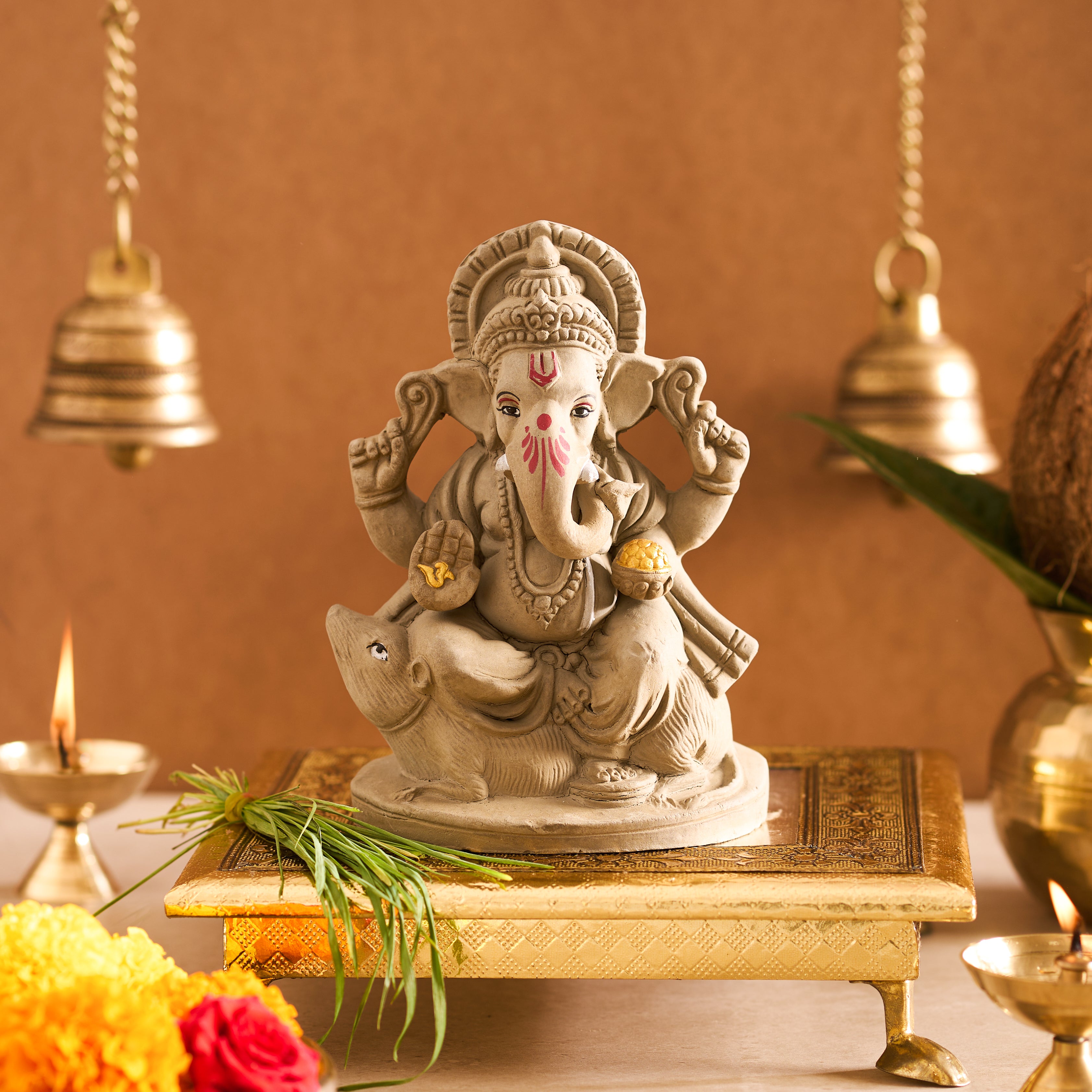 Statue of a deity on a platform with decorative elements and a warm background
