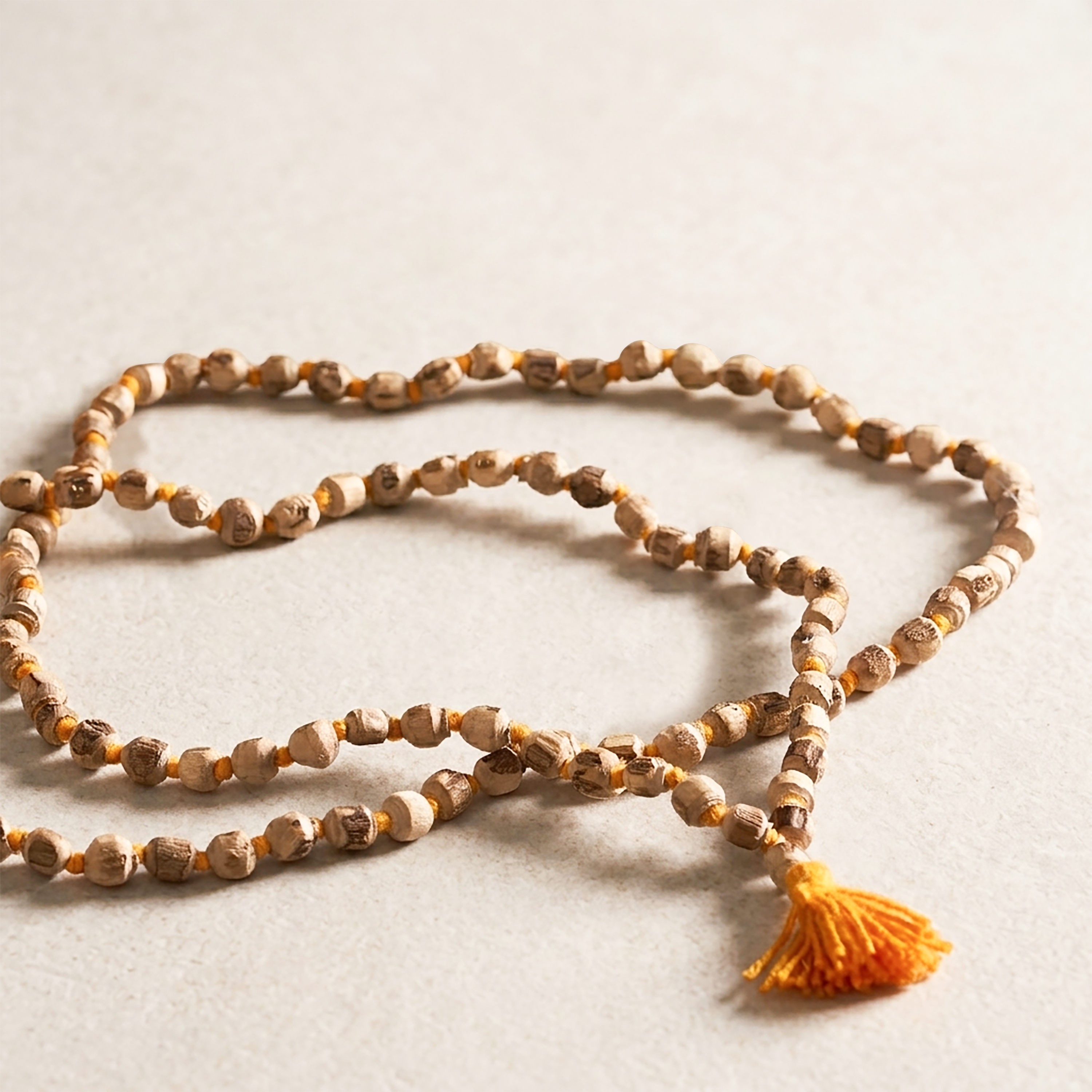 Wooden beaded necklace with a tassel on a light background