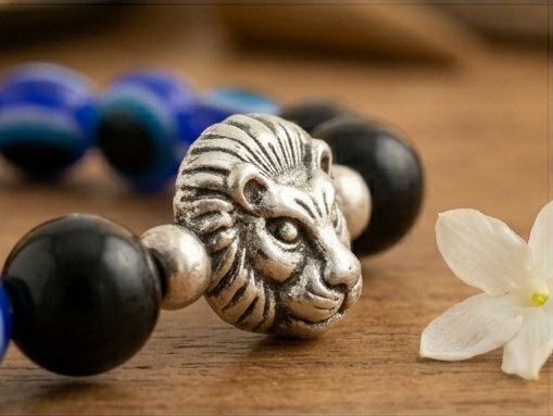 Najari Suraksha Lion Bead Bracelet with lion head charm on a wooden surface, surrounded by decorative items.