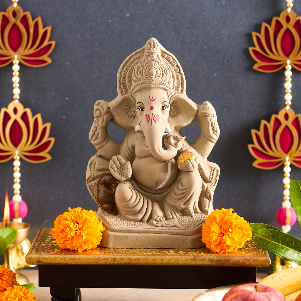 Full straight-on shot of the unglazed grey clay Ganesha idol showcasing its hand-painted facial detailing and integral base.