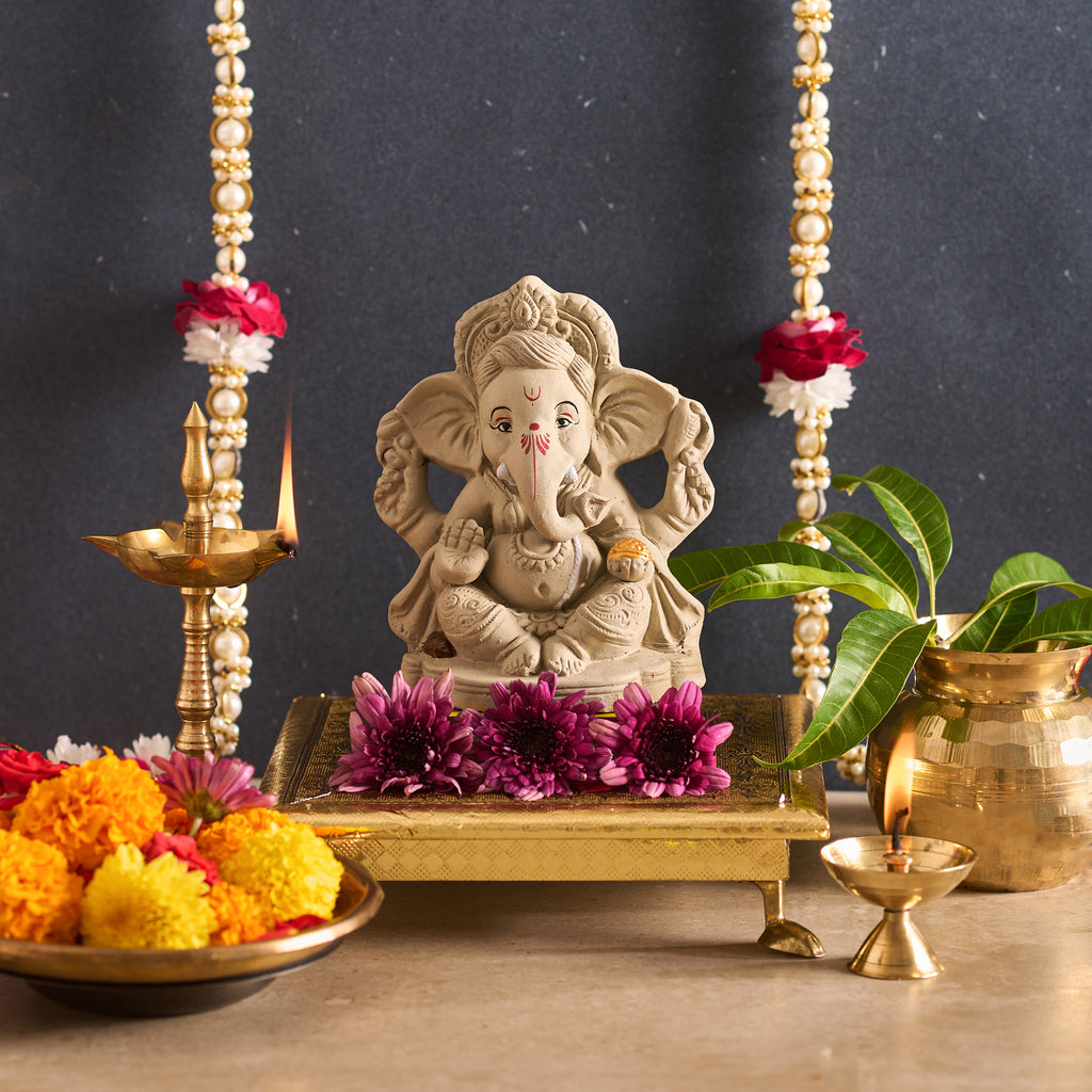 Statue of a deity with flowers and candles on a dark background