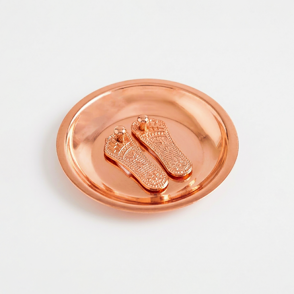 Copper-colored decorative item with embossed feet design on a white background