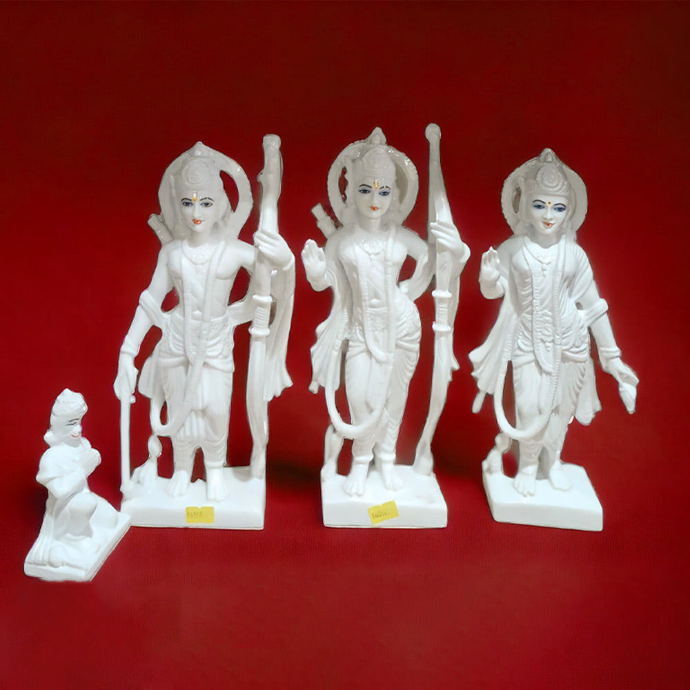 A set of marble statues depicting the figures of Lord Rama, Goddess Sita, Lord Lakshmana, and Lord Hanuman, each intricately carved and displayed against a red background.