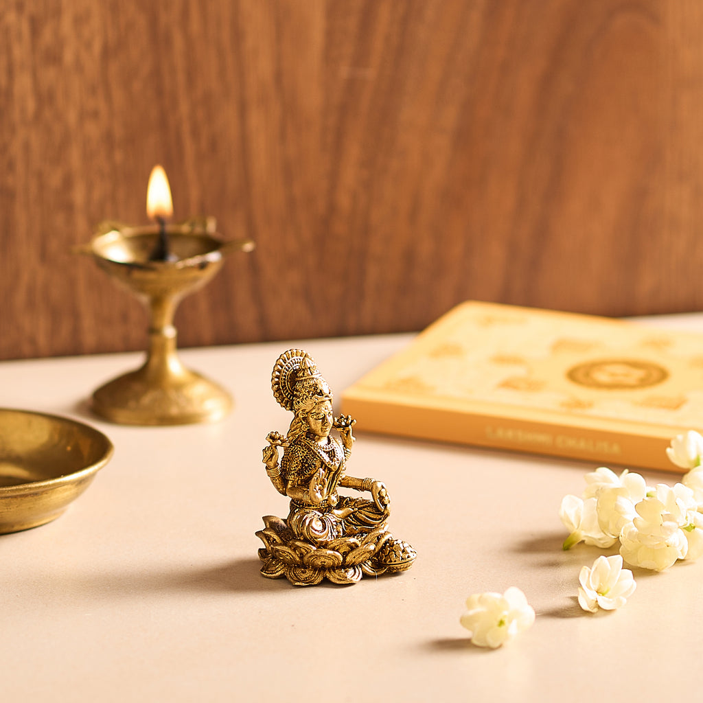 A close-up view focusing on the layered, sculpted brass lotus petals that form the sturdy foundation of the deity figurine.