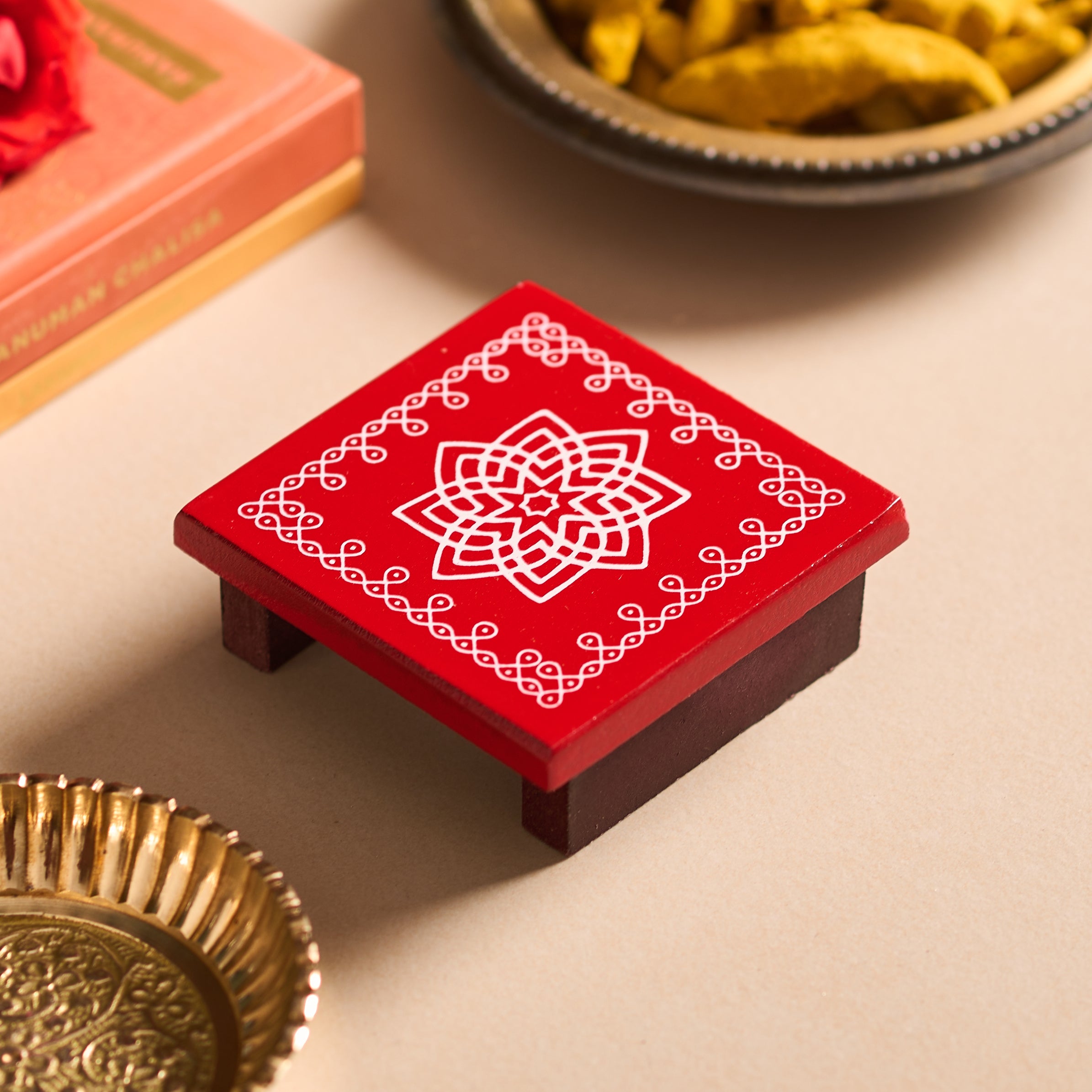 Red decorative box with white patterns on a beige surface