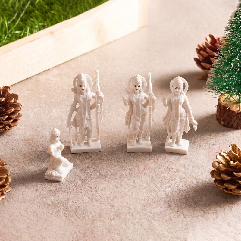 Small white figurines on a light surface with pine cones and a small tree.