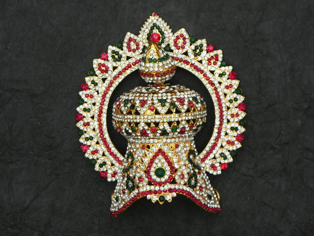 A decorative stone Kirita with metal casing, adorned with red and green gemstones, designed to fit on a god's head.